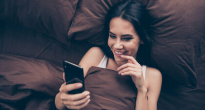 woman texting in bed