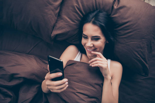 woman texting in bed